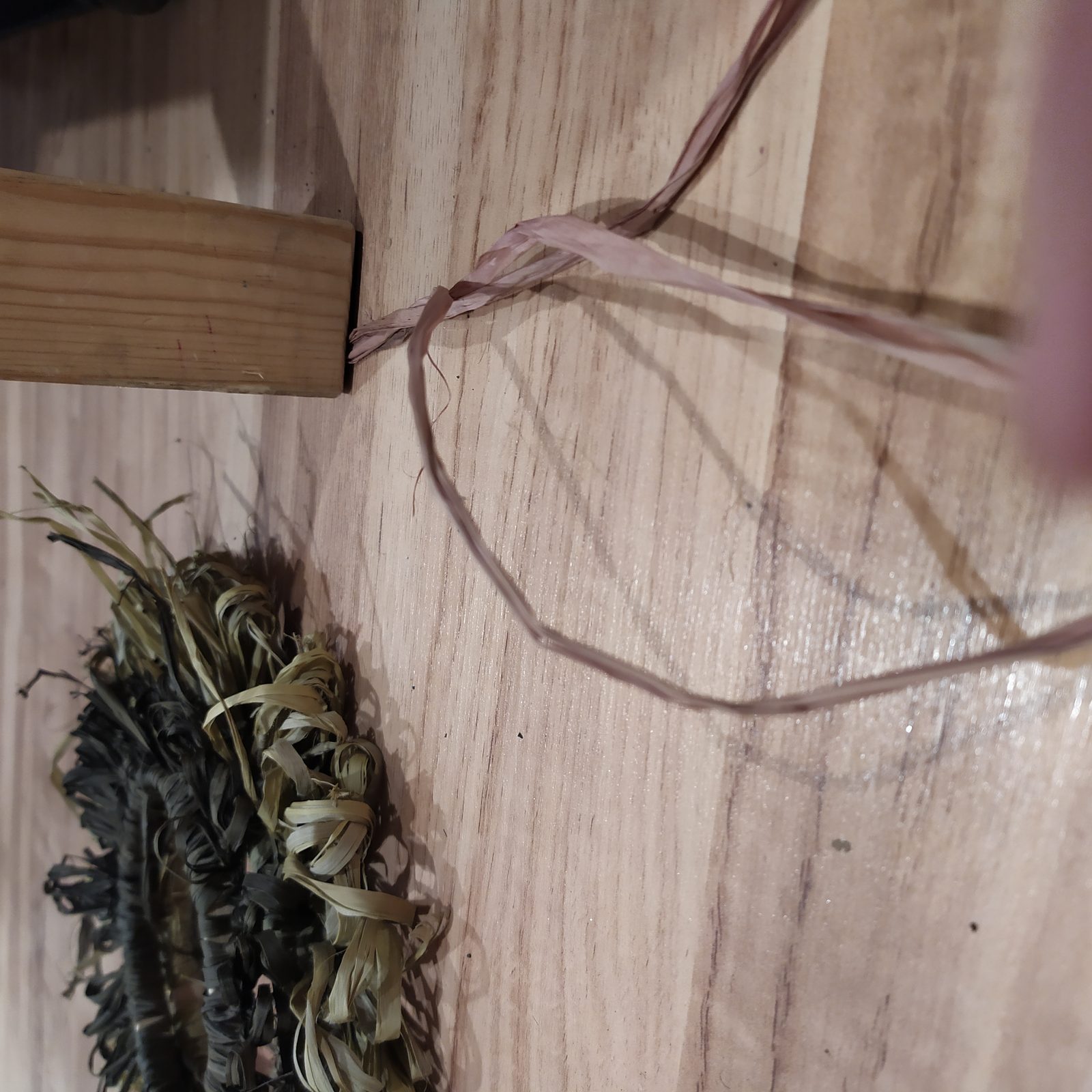 Tressage de brins de raphia teints aux oignons rouges